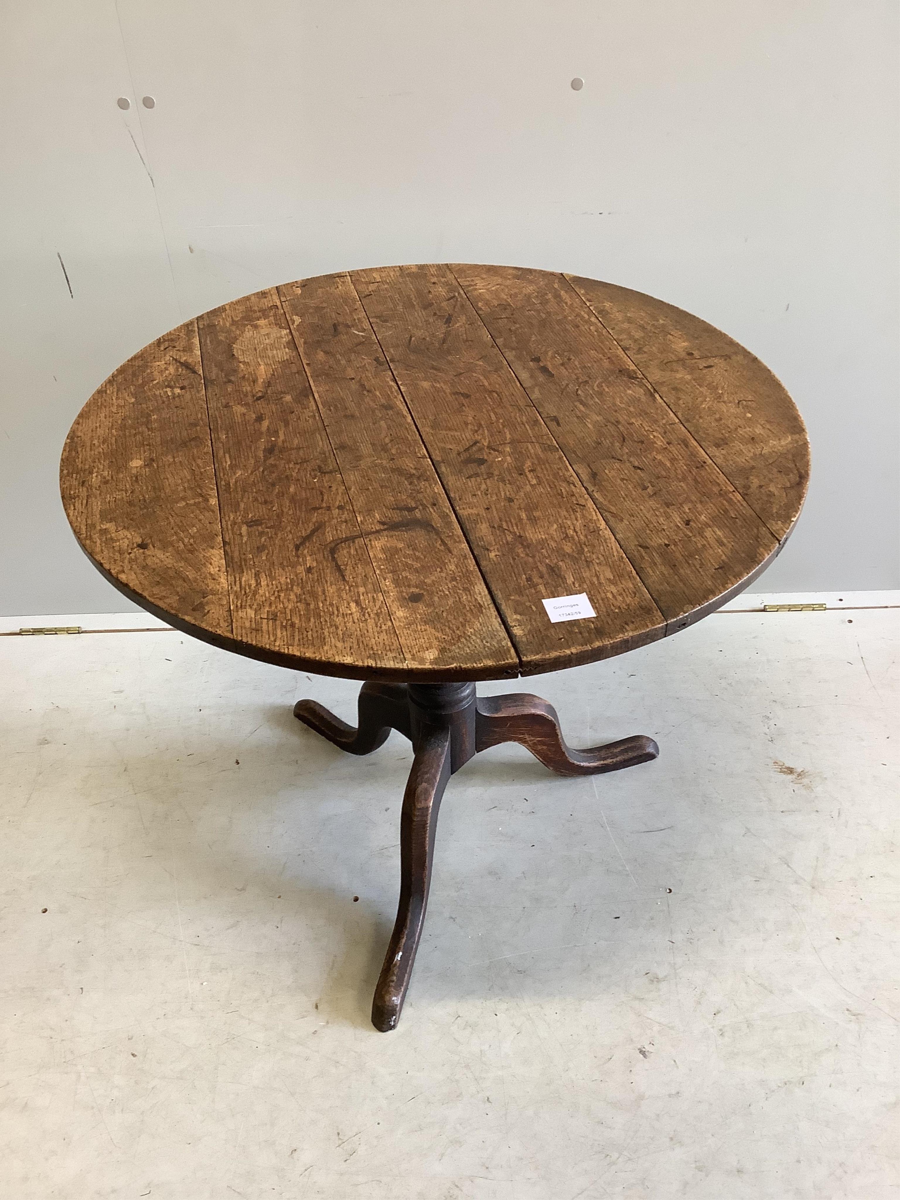 A George III circular oak tilt top tripod table, diameter 82cm, height 70cm. Condition - fair